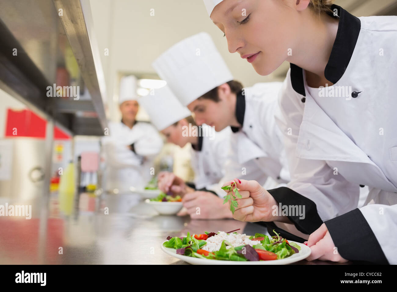 Chef finishing her salad in culinary class Stock Photo