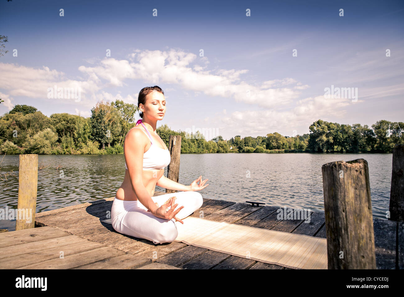 young woman making yoga exercise at a lake Stock Photo - Alamy
