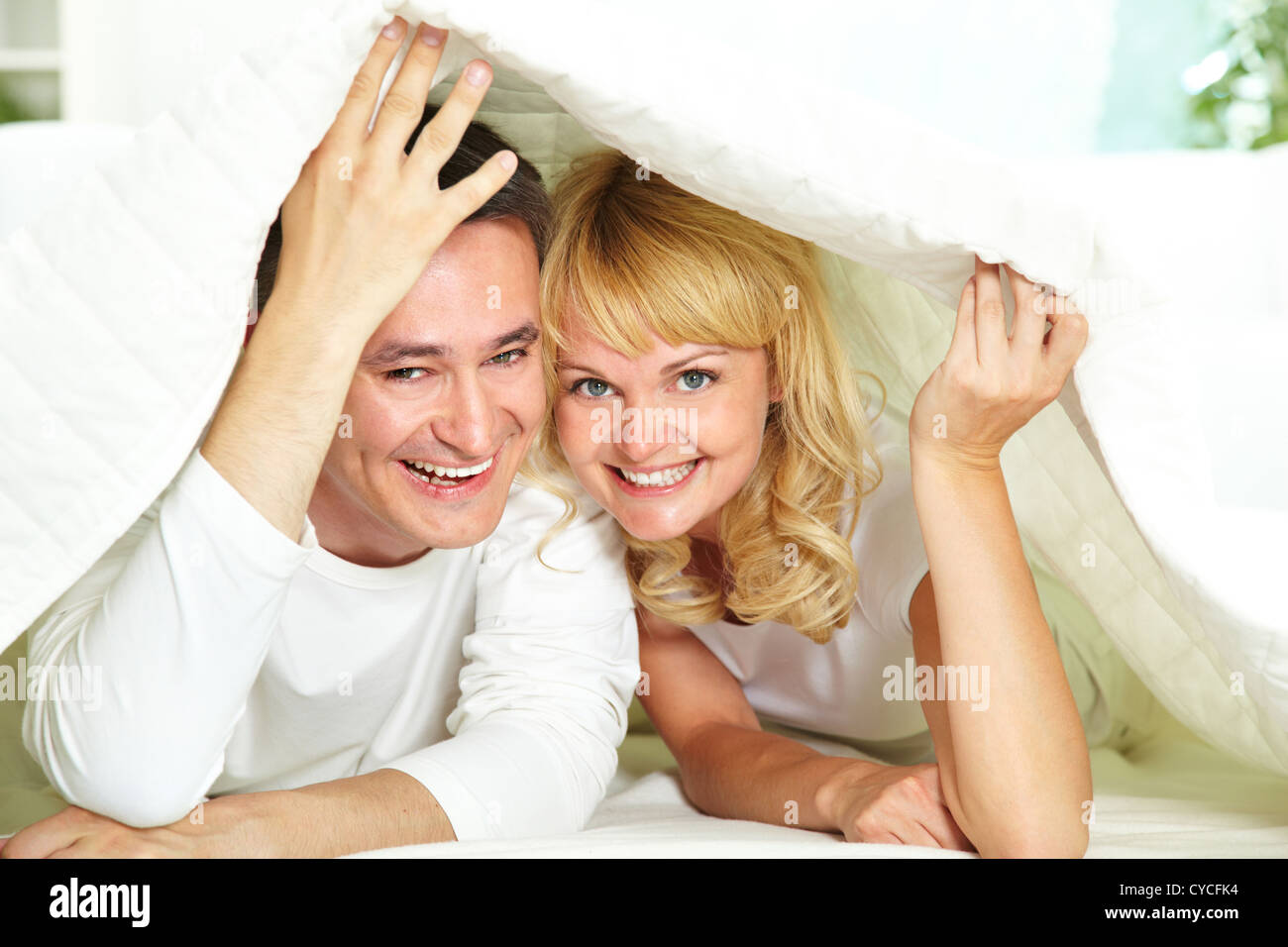 Portrait of amorous couple holding blanket over heads Stock Photo Alamy