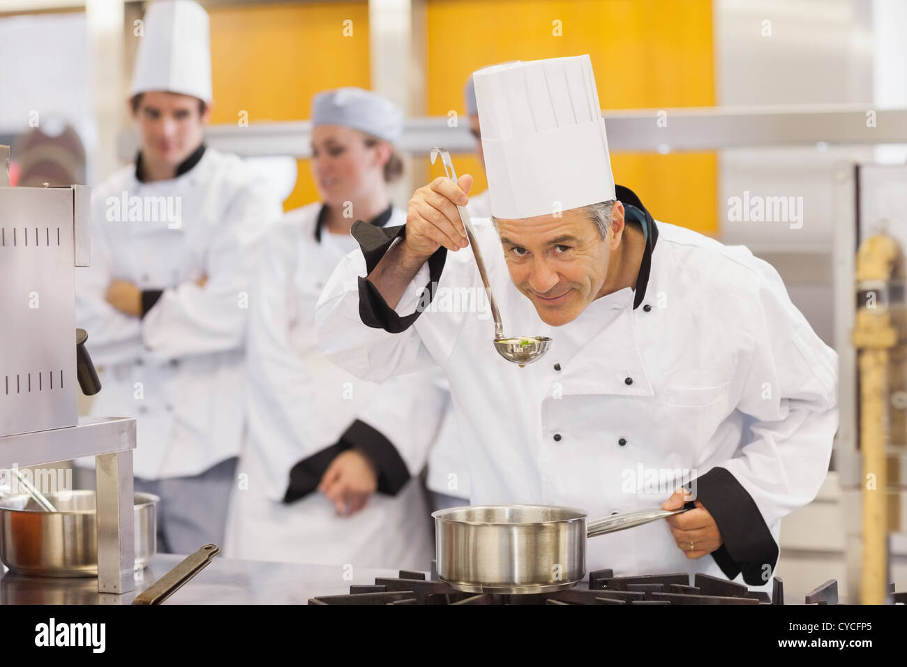 Smiling chef tasting his students work Stock Photo