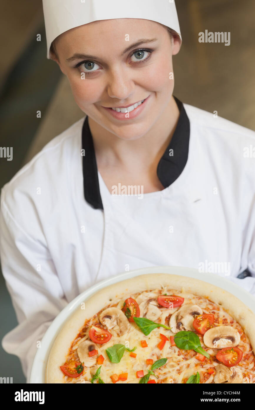 Female cook holding a pizza Stock Photo