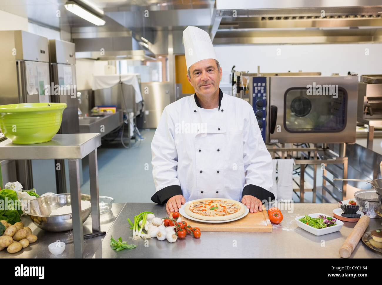 Chef standing in the kitchen with pizza Stock Photo
