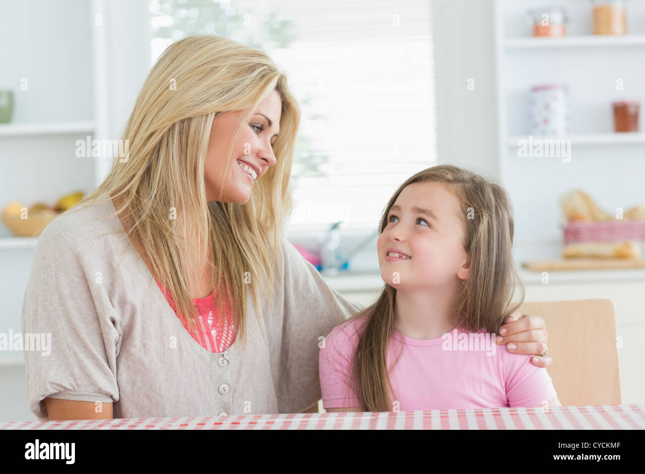 Mother and child looking at each other in kitchen Stock Photo - Alamy