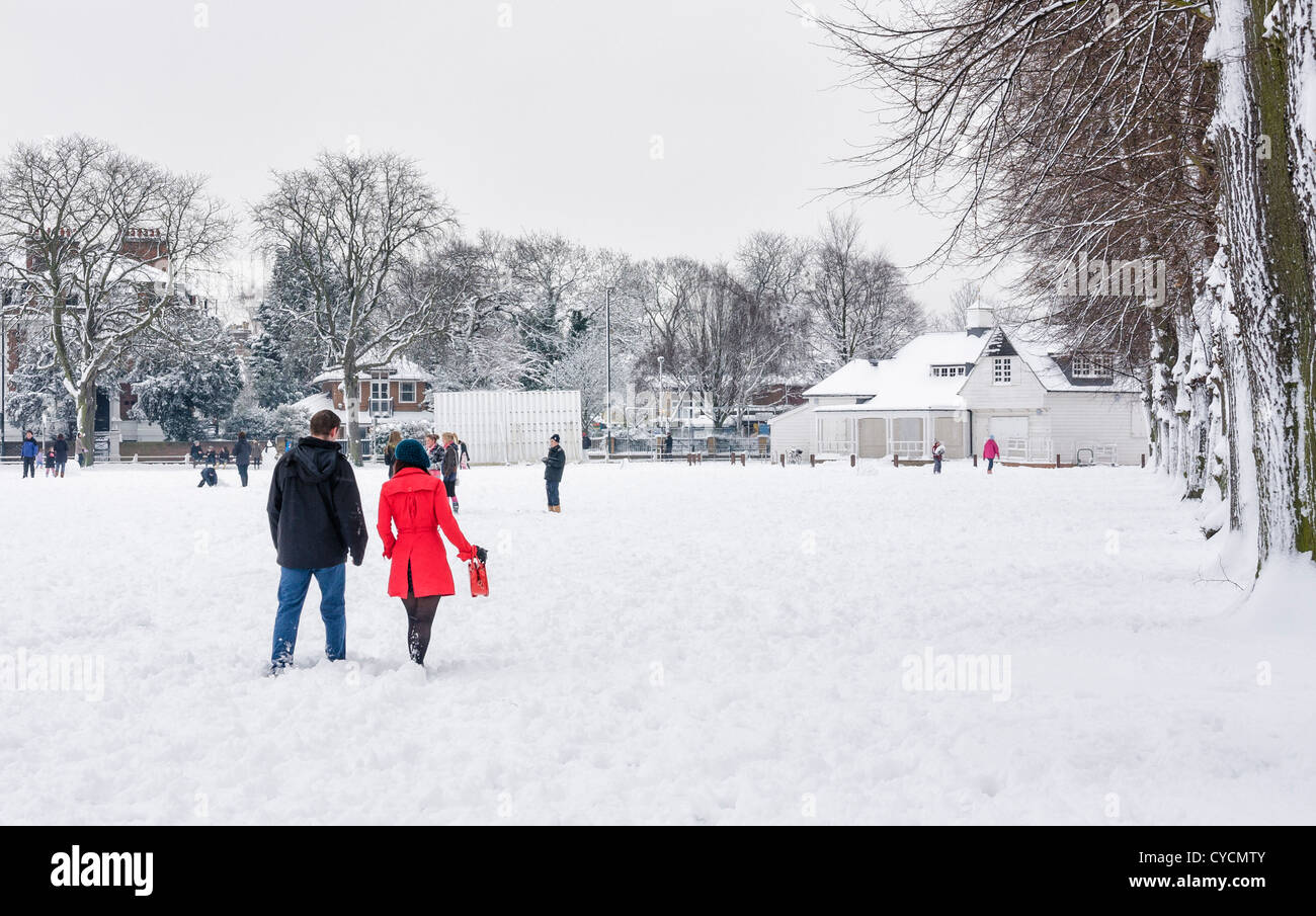 Couple walking on a snow-covered Twickenham GreenLondon Borough of Richmond ,Greater London,UK Stock Photo