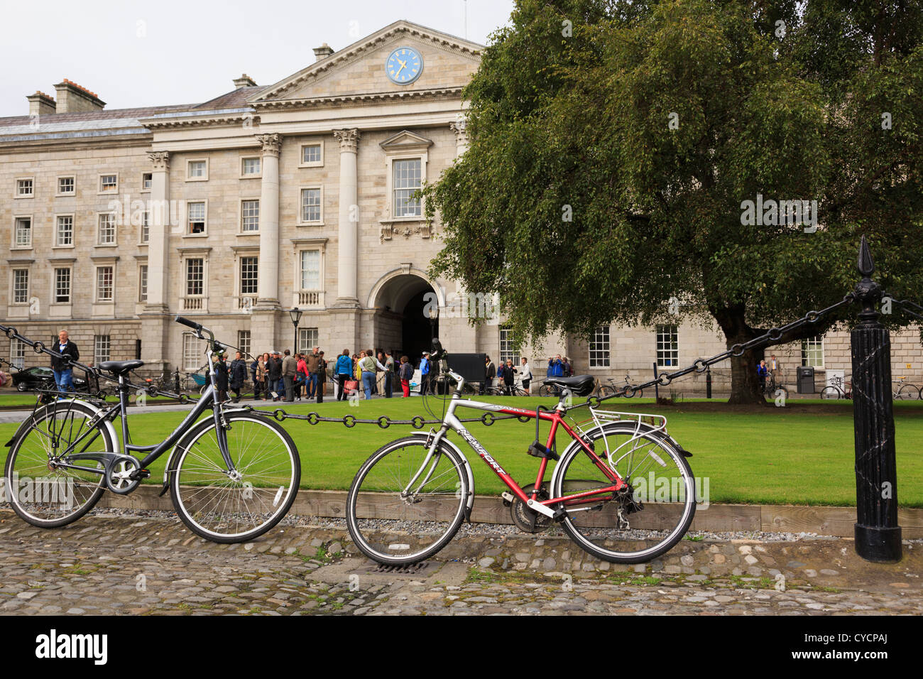Student's bicycles chained to a fence on Trinity College University of Dublin campus in College Green Dublin Ireland Eire Stock Photo