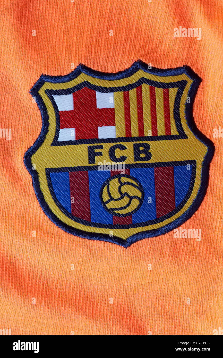 FCB FC Barcelona logo badge on orange coloured football shirt Stock Photo