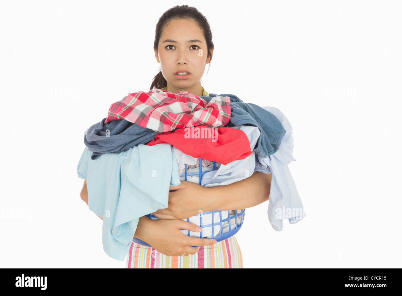 Frowning woman holding basket which is full of dirty laundry Stock Photo