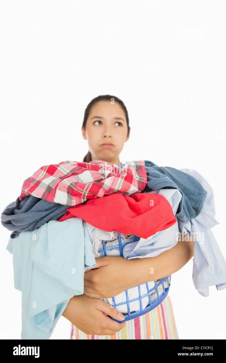 Overworked woman holding basket full of laundry Stock Photo
