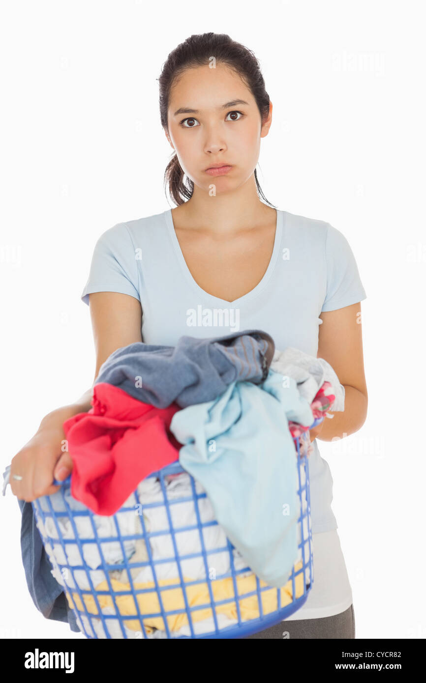 Bored woman holding a basket overflowing of laundry Stock Photo