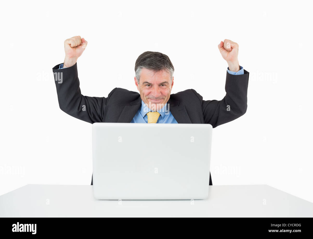 Cheering man sitting at his desk with laptop Stock Photo - Alamy
