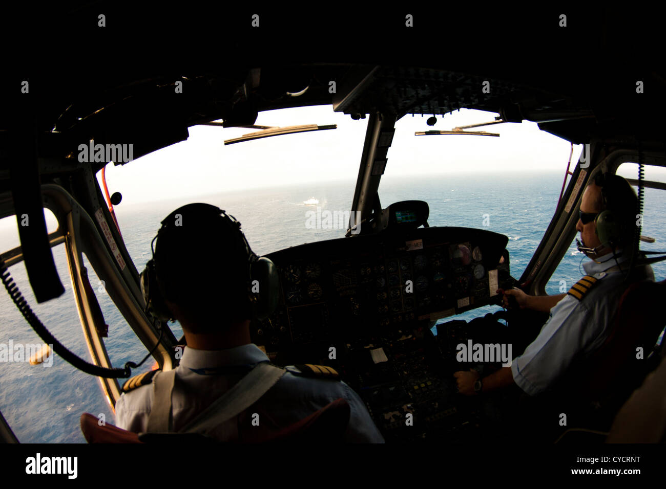 Helicopter cabin with pilots, going to offshore area, to land on oil rig platform Stock Photo