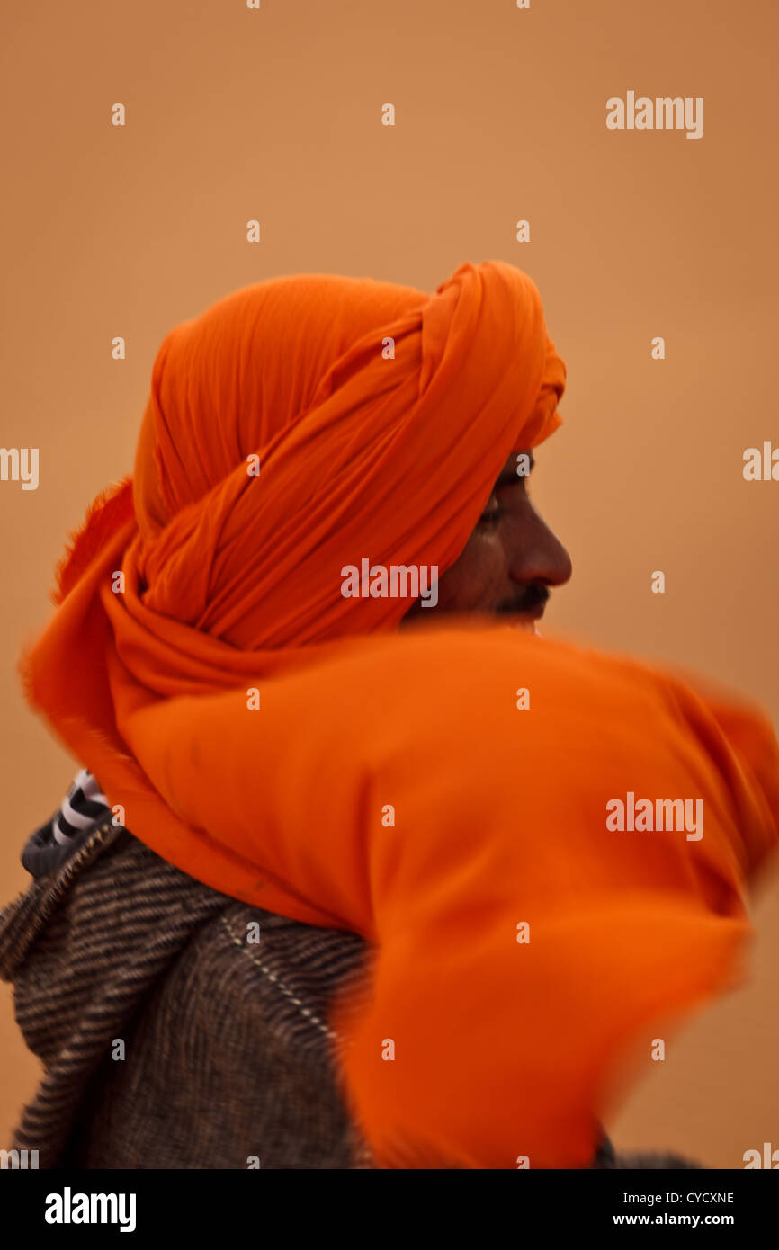 Profile of the face of a Berber man in the Sahara with turban head garb blowing in the wind Merzouga, Morocco. Stock Photo