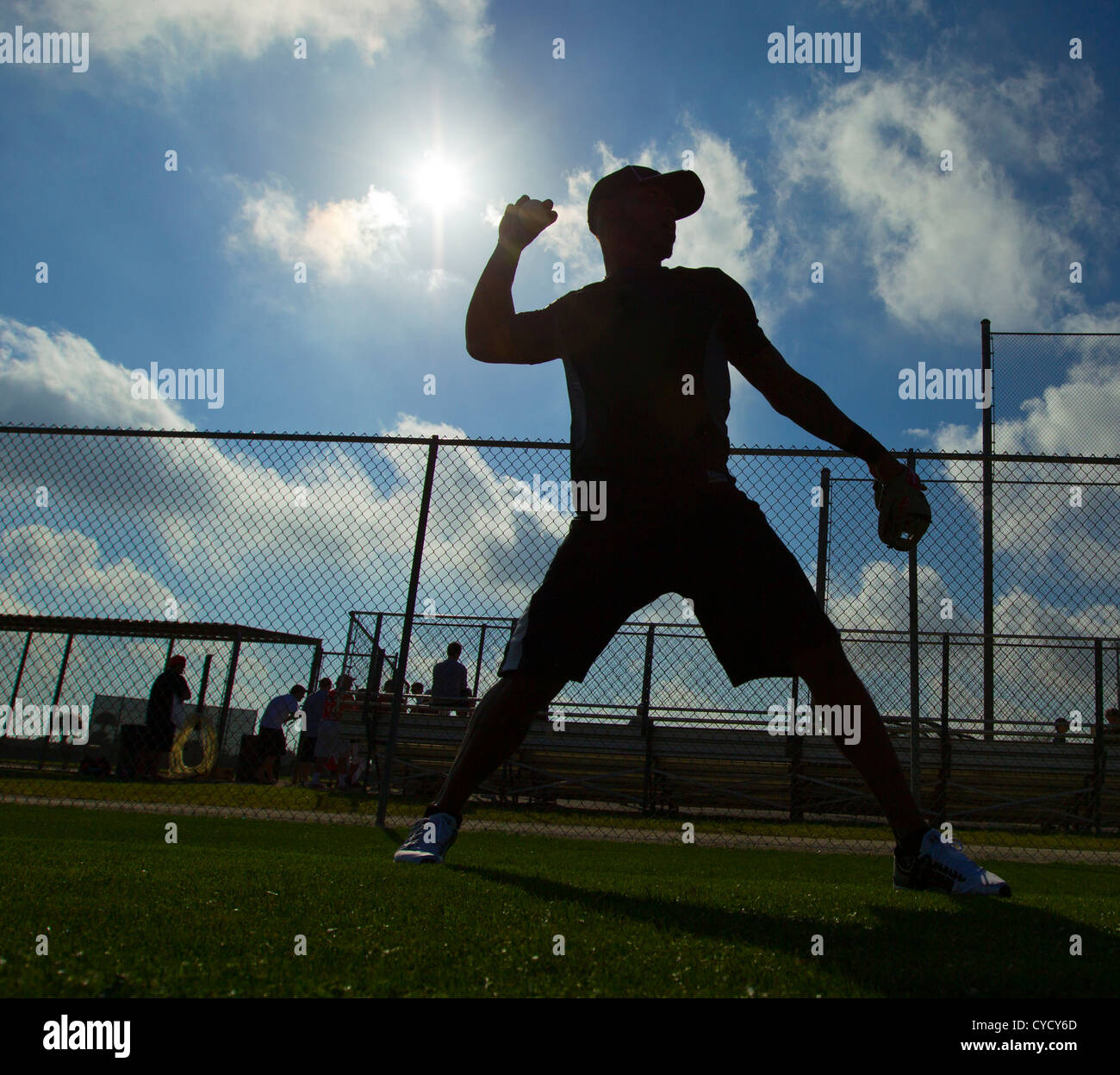 A silhouette of a baseball player throwing a ball Stock Photo