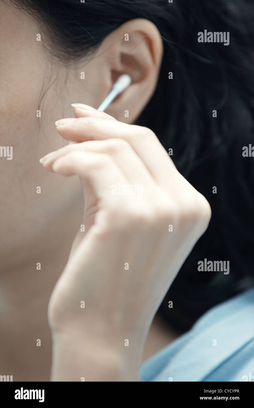 Woman holding cotton swab and cleaning ear Stock Photo Alamy
