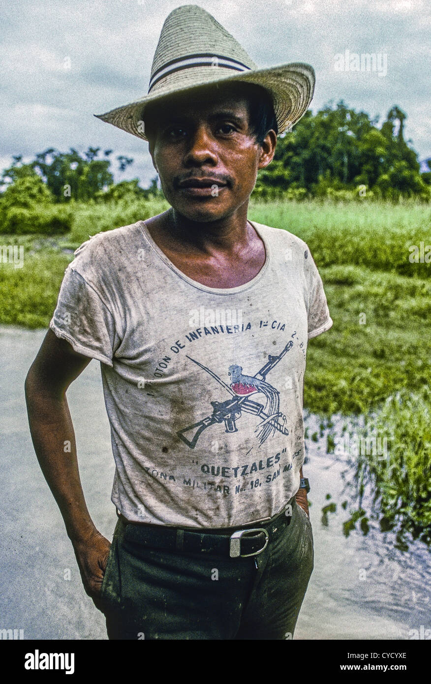 Guatemalan Kekchi man wearing the t-shirt of an army infantry division, Quetzales, in the village of Chinebal on Lake Isabel. Stock Photo