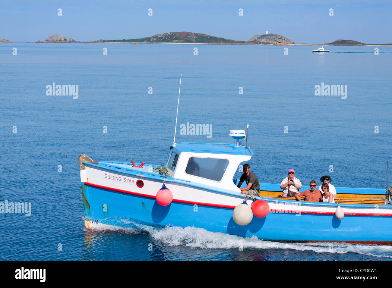 St Mary's boat traveling between islands; St Helen's and Round Island behind; Isles of Scilly; UK Stock Photo