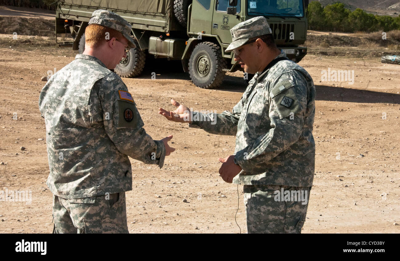 Sgt. 1st Class Augustine Haro (right), a native of Modesto, Calif., and platoon sergeant of the 1st Platoon, 541st Sapper Company, 54th Engineer Battalion, 18th Engineer Brigade presents Sgt. Benjamin Boggess, a native of Spring Lake, N.C., a company chal Stock Photo