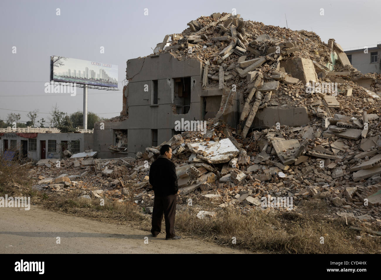 A man stands next to a building being demolished to build new construction near Taihu Lake, China. Stock Photo