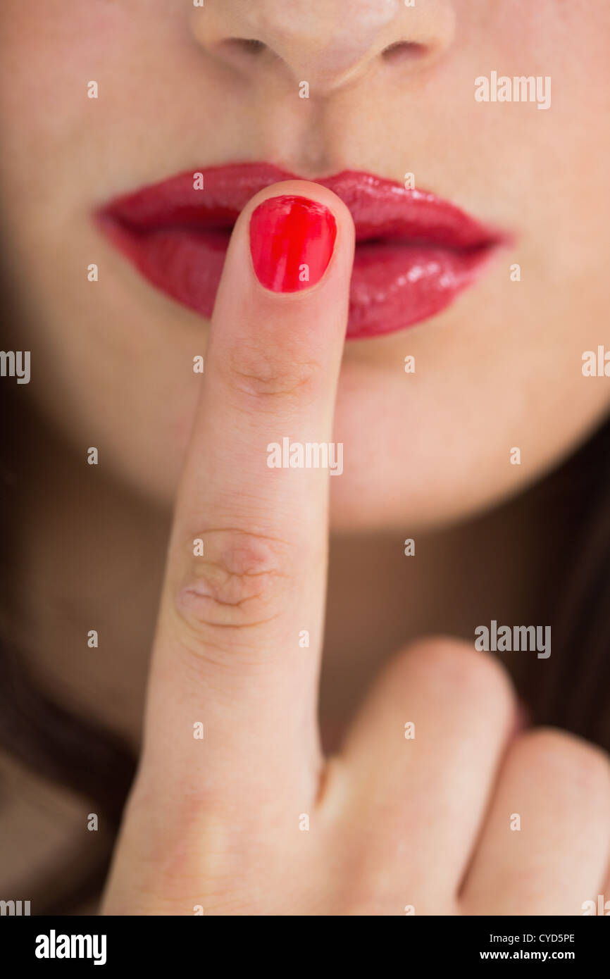 Woman touching her red lips with red nail Stock Photo