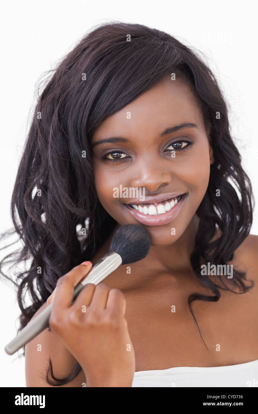 Woman holding makeup brush to face Stock Photo