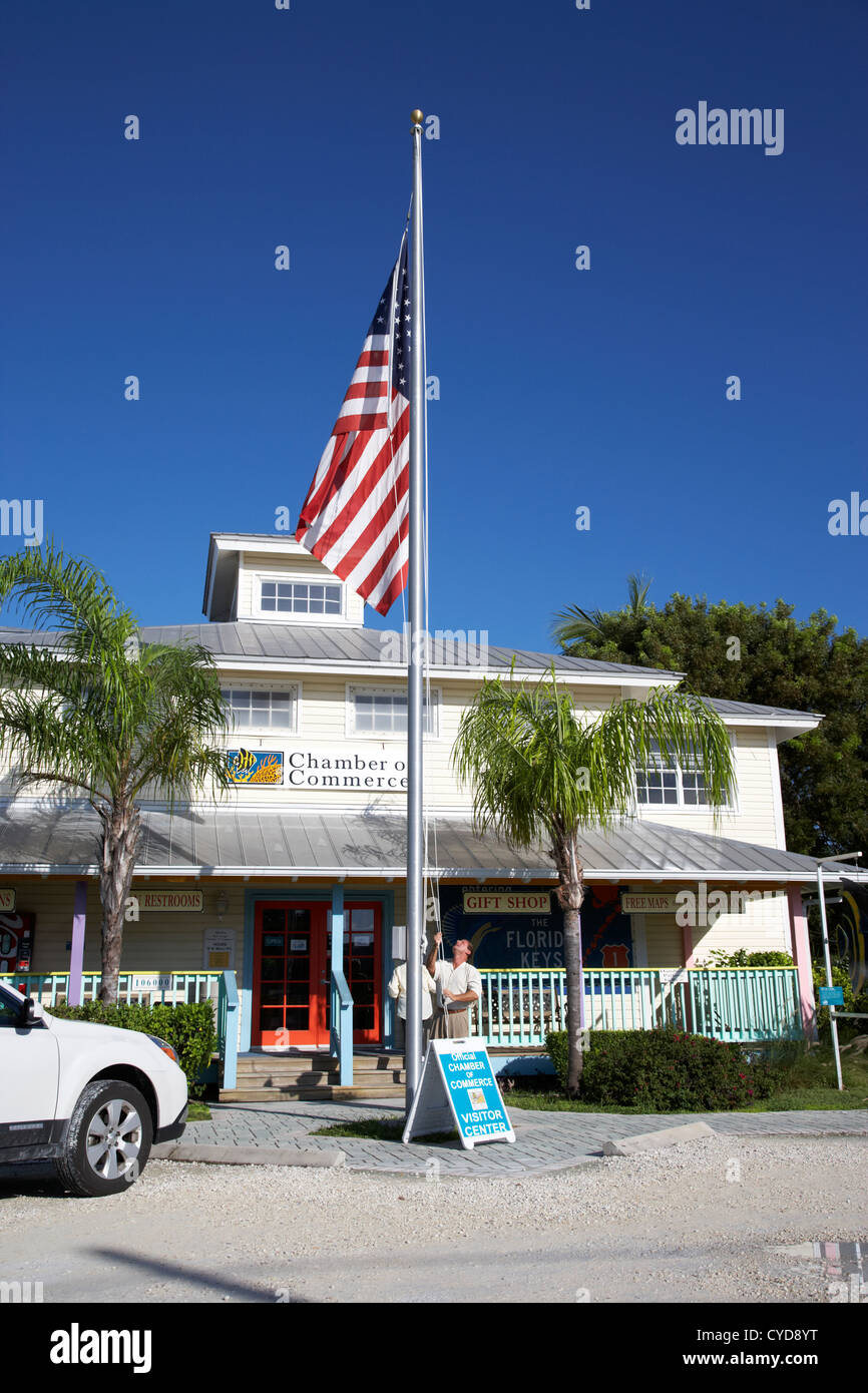 raising the american flag on a flagpole outside the chamber of commerce building in key largo florida keys usa Stock Photo