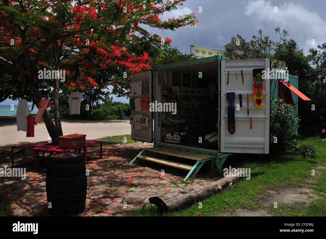 Sun shade view container gift-shop, face masks, T-shirts, red Flamboyant Tree, Paradise Beach car-park, Carriacou, West Indies Stock Photo