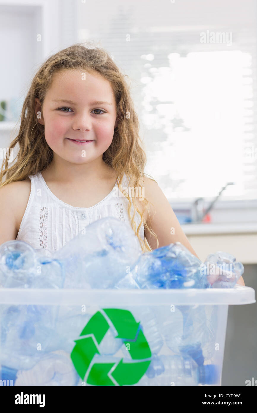 Little girl carrying box full of empty plastic bottles Stock Photo