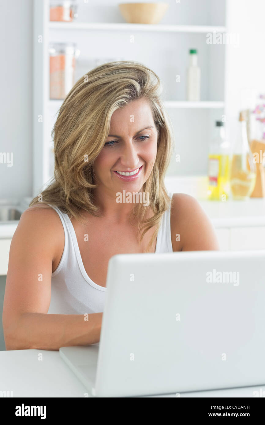 Woman using laptop in the kitchen Stock Photo