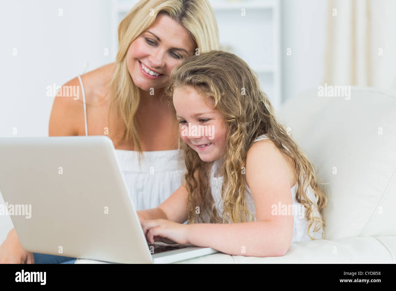 Daughter and mother working with notebook Stock Photo