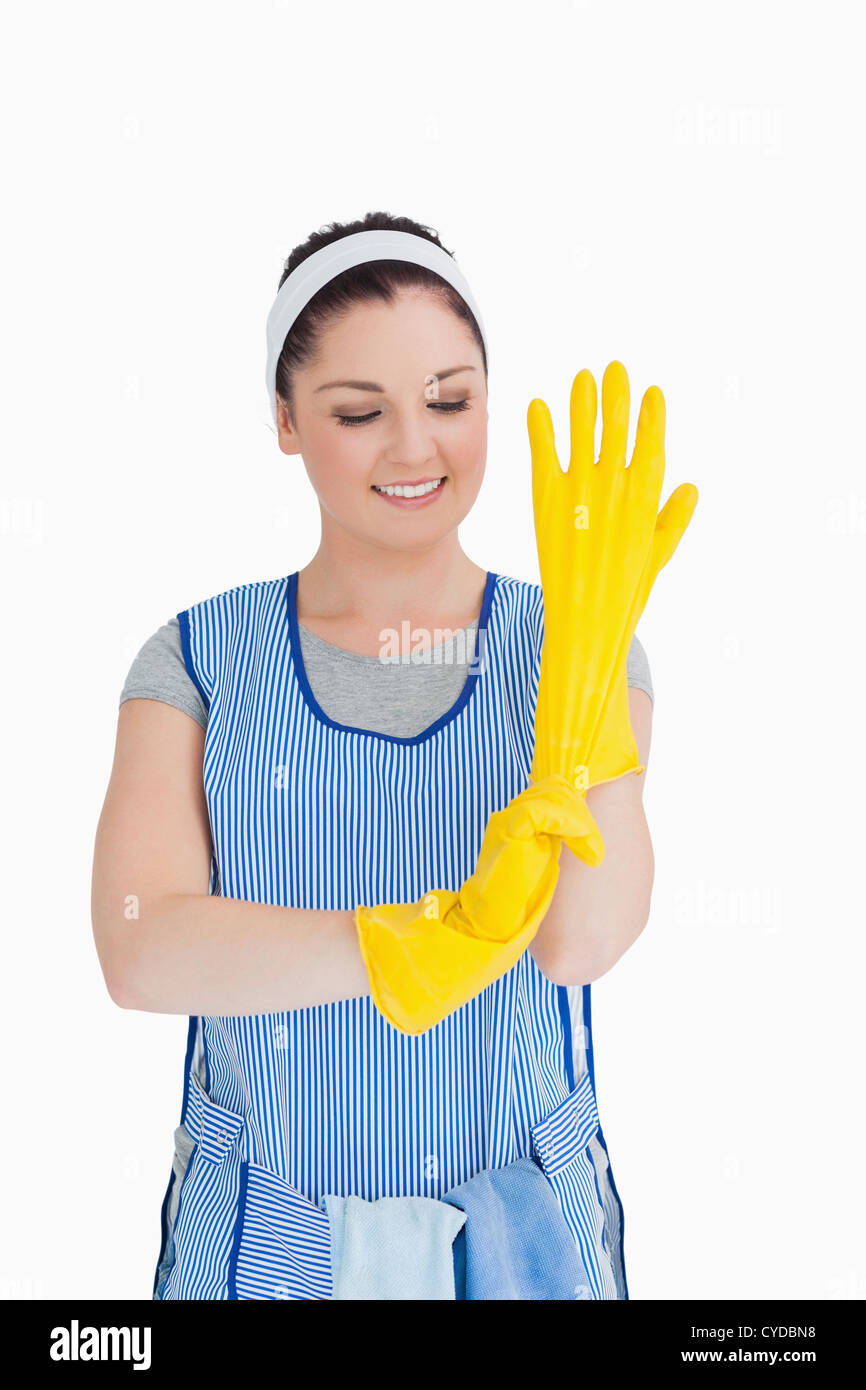 Cleaner woman putting on yellow gloves Stock Photo