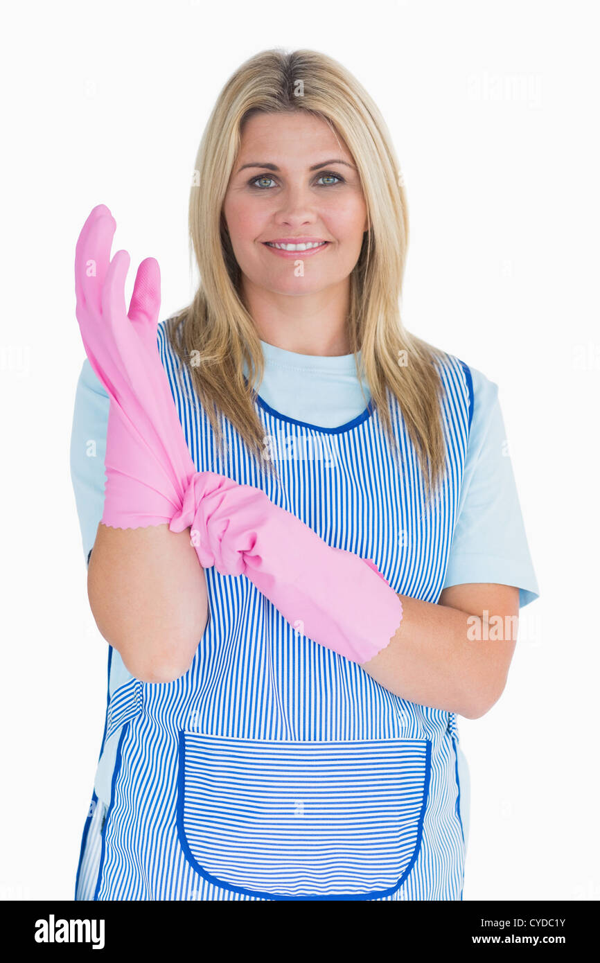 Cleaner woman putting pink gloves on Stock Photo