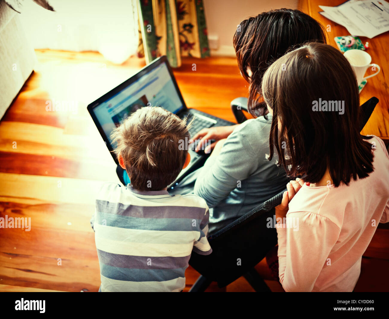 Mother, son and daughter watch videos on the web. Stock Photo