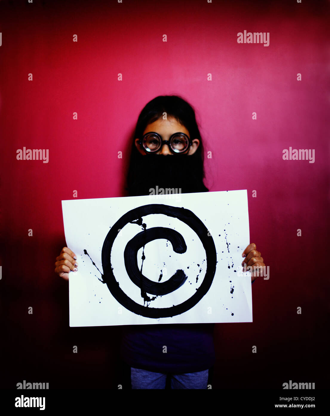 The professor says, 'Hands off: it's Copyright'. Girl with fake beard and glasses holds copyright symbol. Stock Photo