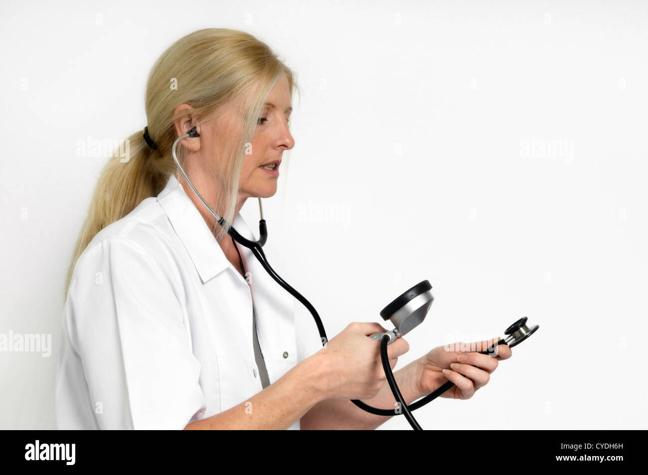 Caucasian woman with stethoscope and blood pressure monitor against a white background Stock Photo