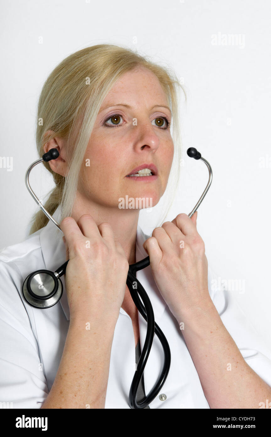 Caucasian woman in white doctors coat and stethoscope against a white background Stock Photo