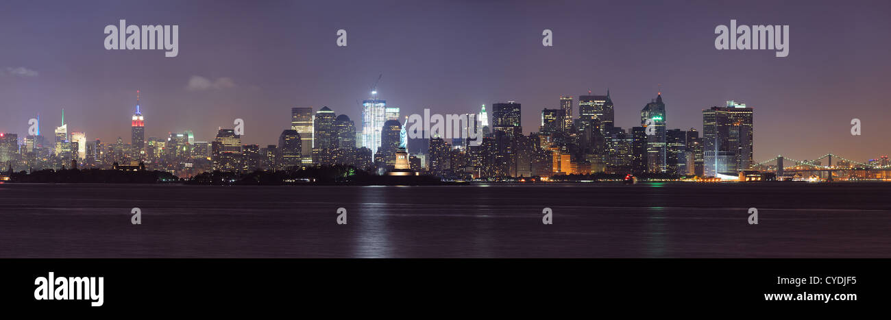 New York City lower Manhattan skyline at night with Statue of Liberty ...