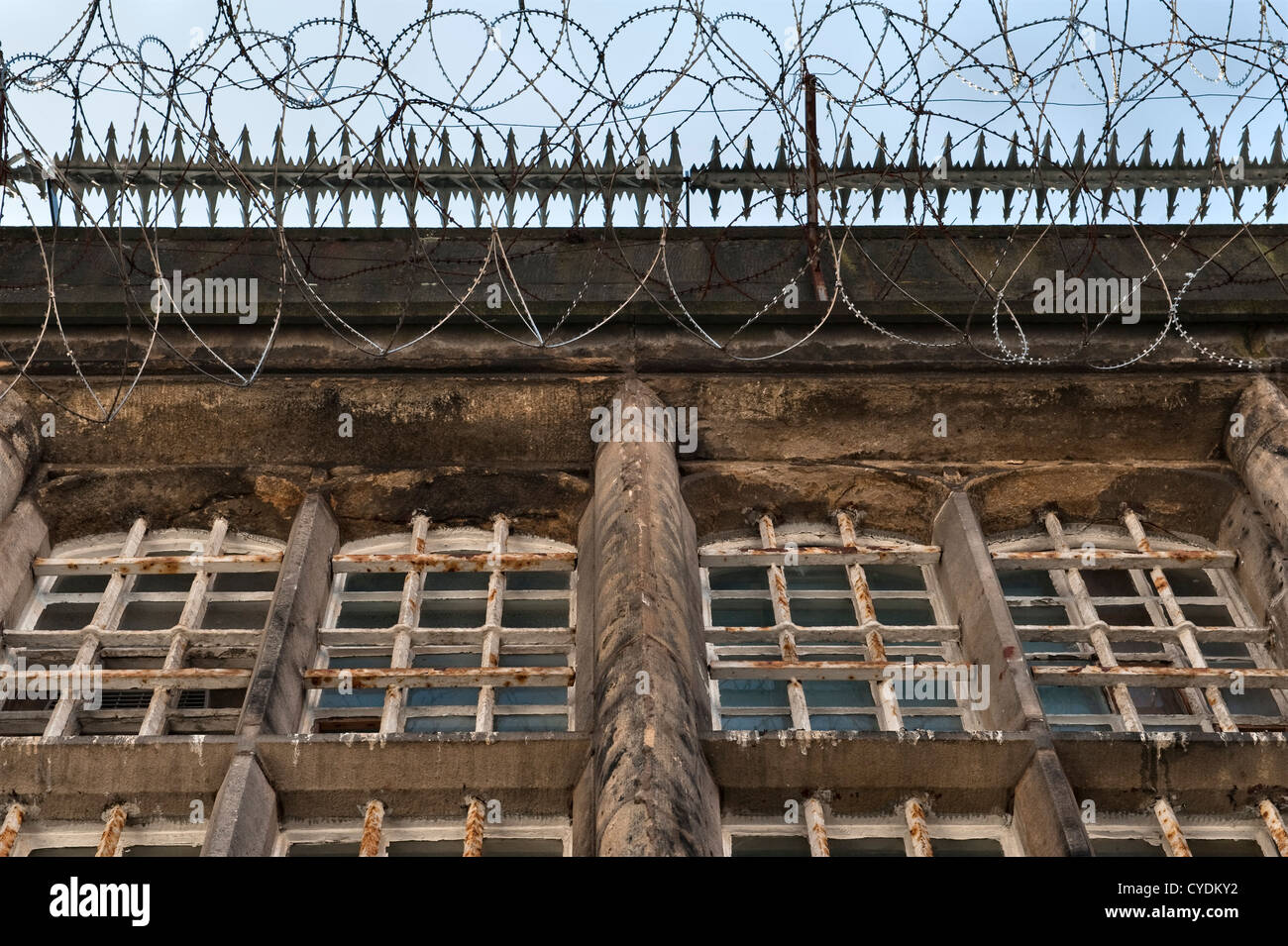 Bars and razor wire prevent access to the roof of a recently abandoned prison in the UK Stock Photo