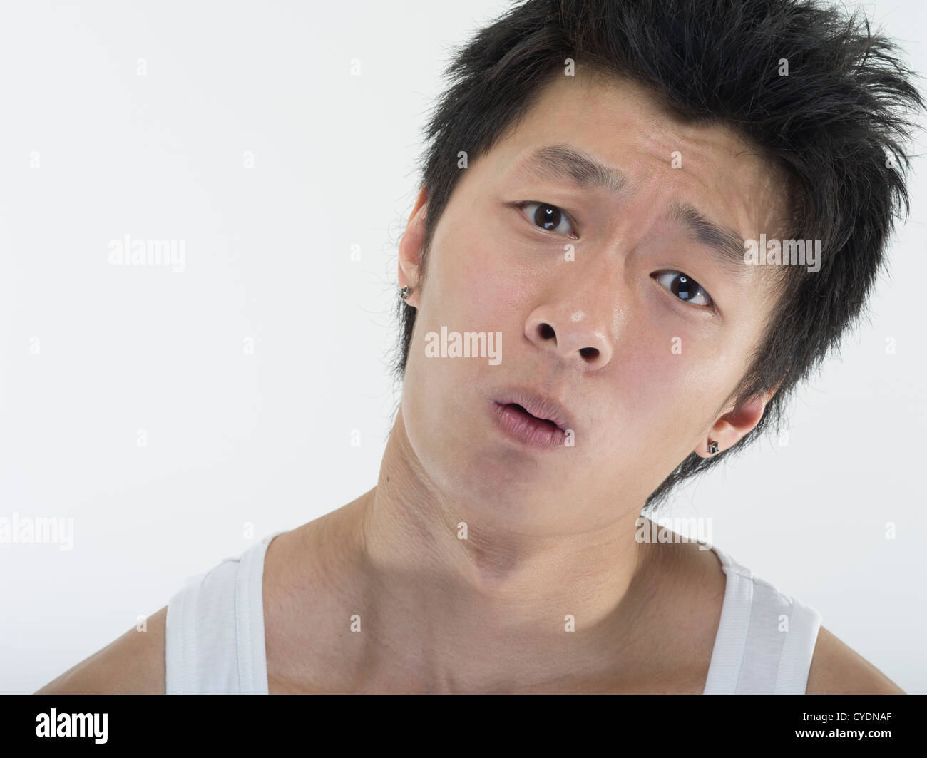 Dazed and confused young asian man on white background Stock Photo