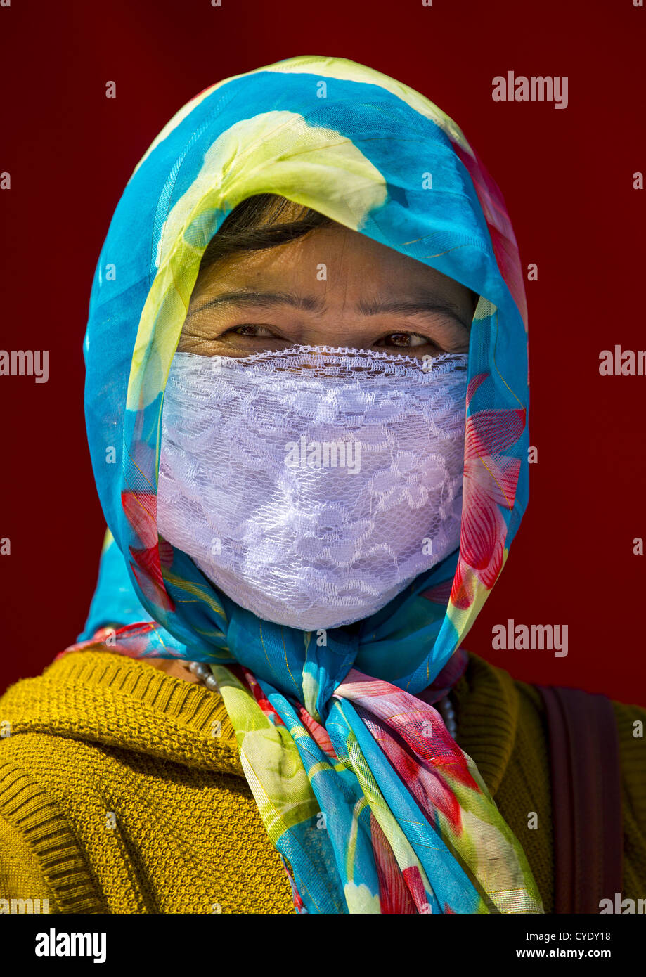 Uyghur Woman With Covered Face And Colourful Headscarf, Xinjiang Uyghur Autonomous Region, China Stock Photo