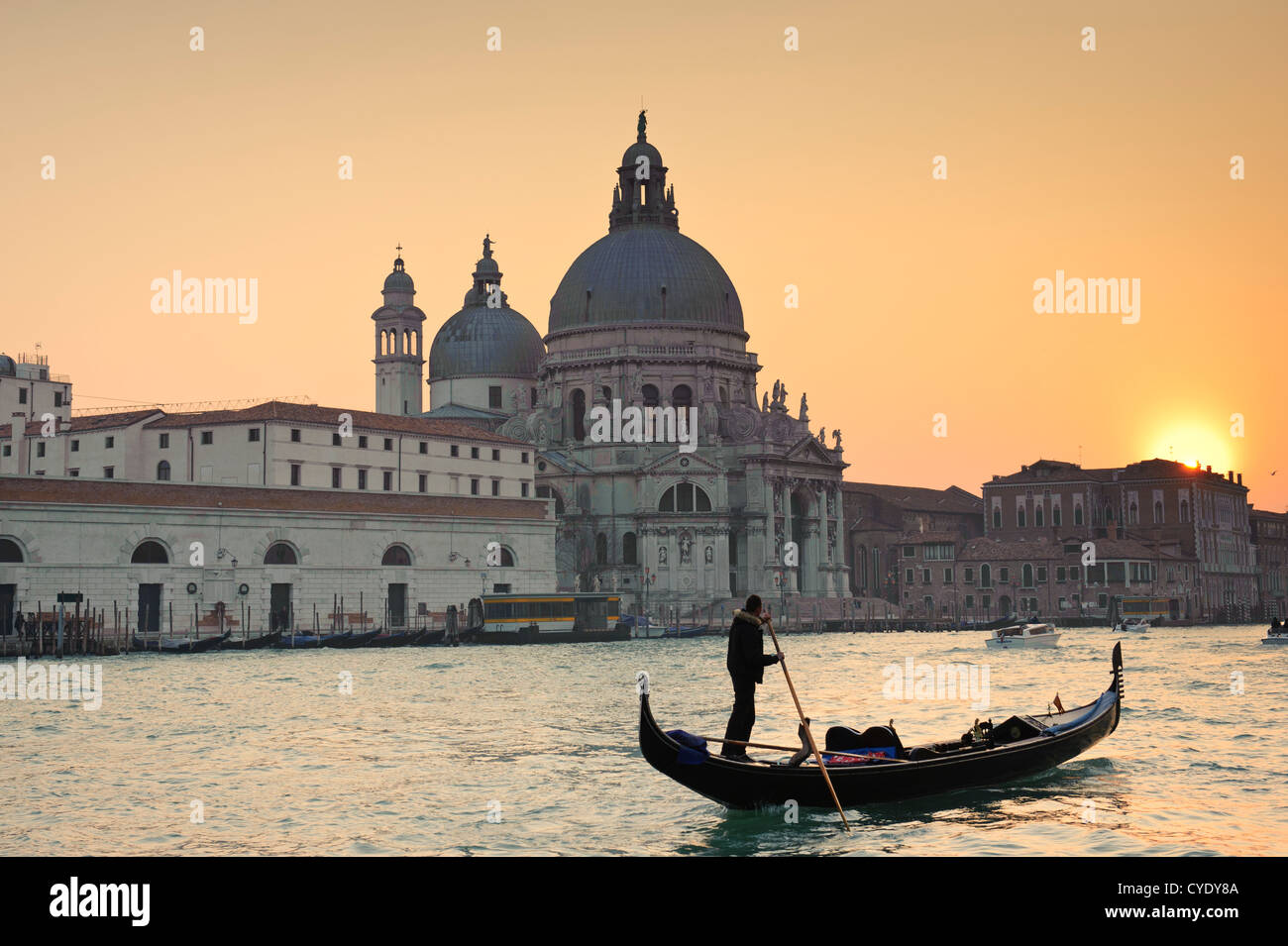A Gondola in front of the Santa Maria della Salute Church at sunset time, Venice, Veneto, Italy. Stock Photo