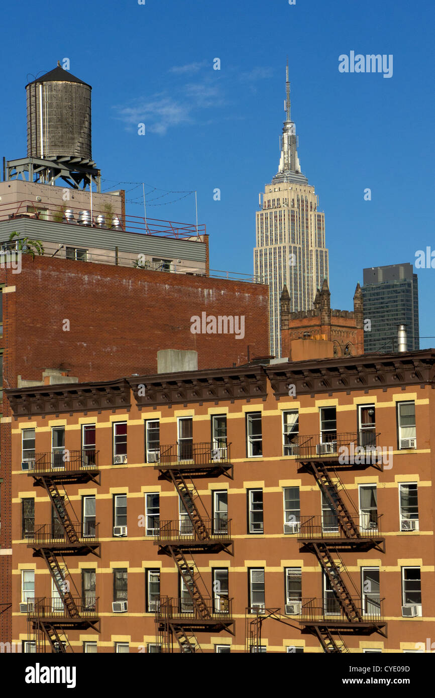 Midtown Manhattan with Empire state building, roof top water storage tanks, apartment block and fire escapes, New York Stock Photo