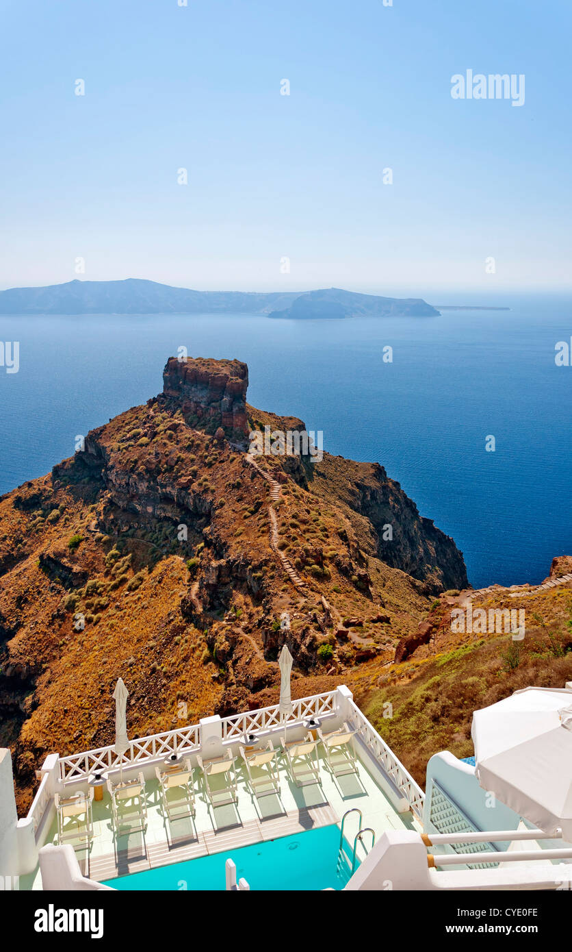 An image from Santorini of a typical luxury pool overlooking the rock of skaros with the volcano in the background. Stock Photo