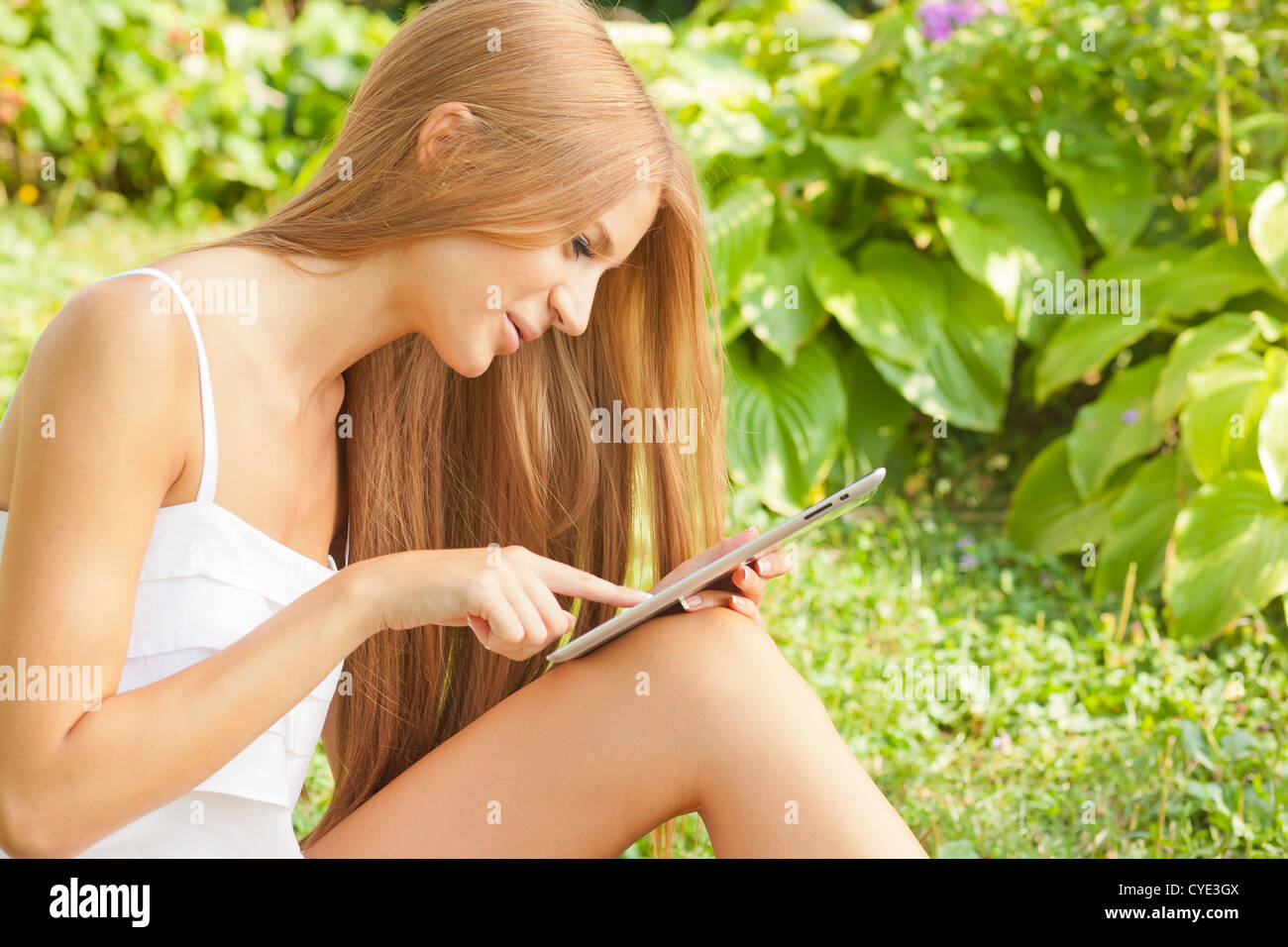 Beautiful Woman With Tablet Computer In Park Garden Stock Photo