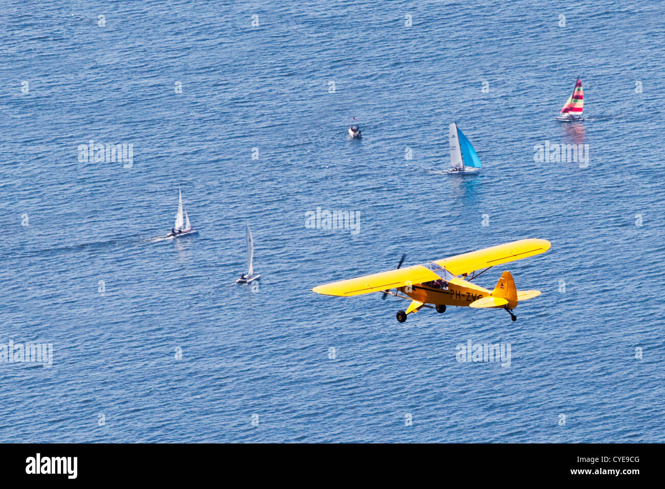 Scheveningen, The Hague. Small airplane, a Piper Cub, flying over catamarans, sailing in the North Sea. Aerial. Stock Photo
