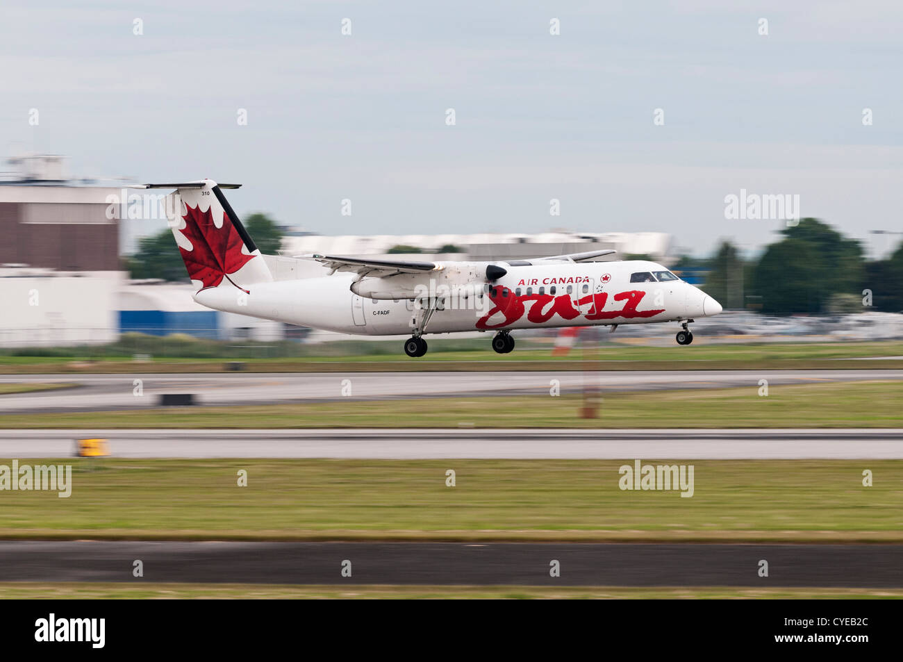 An Air Canada Jazz Dash 8 turboprop airliner. Blurred by camera panning at slow shutter speed with the landing aircraft Stock Photo