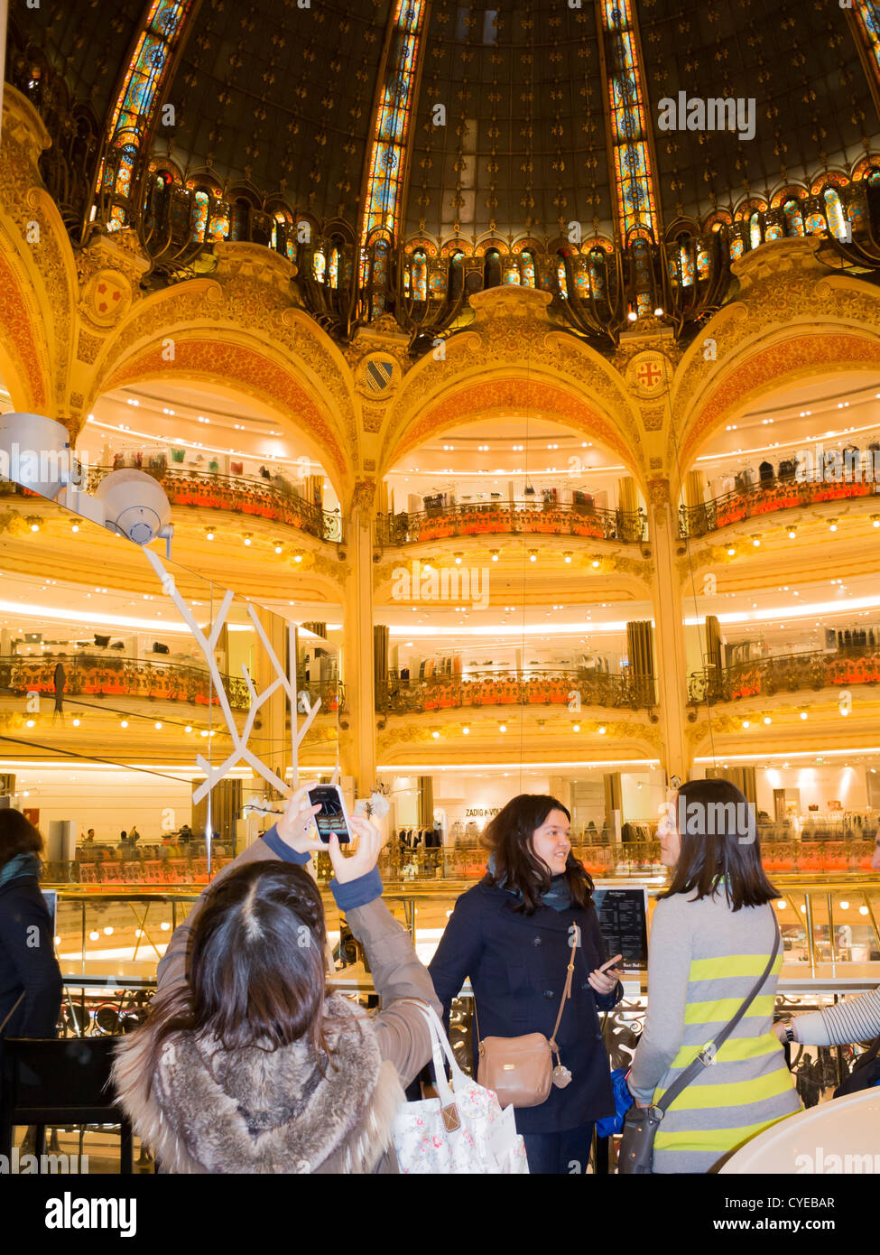 Paris, France, a tourist photographing ceiling with stained glass in art nouveau architecture at Galeries Lafayette Stock Photo