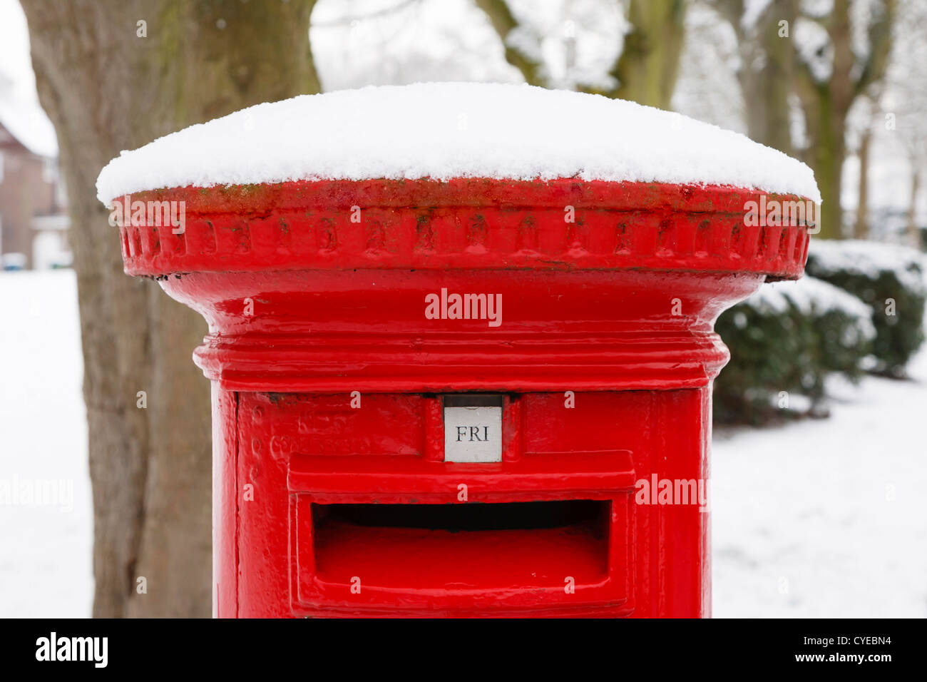 Traditional English red postbox covered with snow Stock Photo