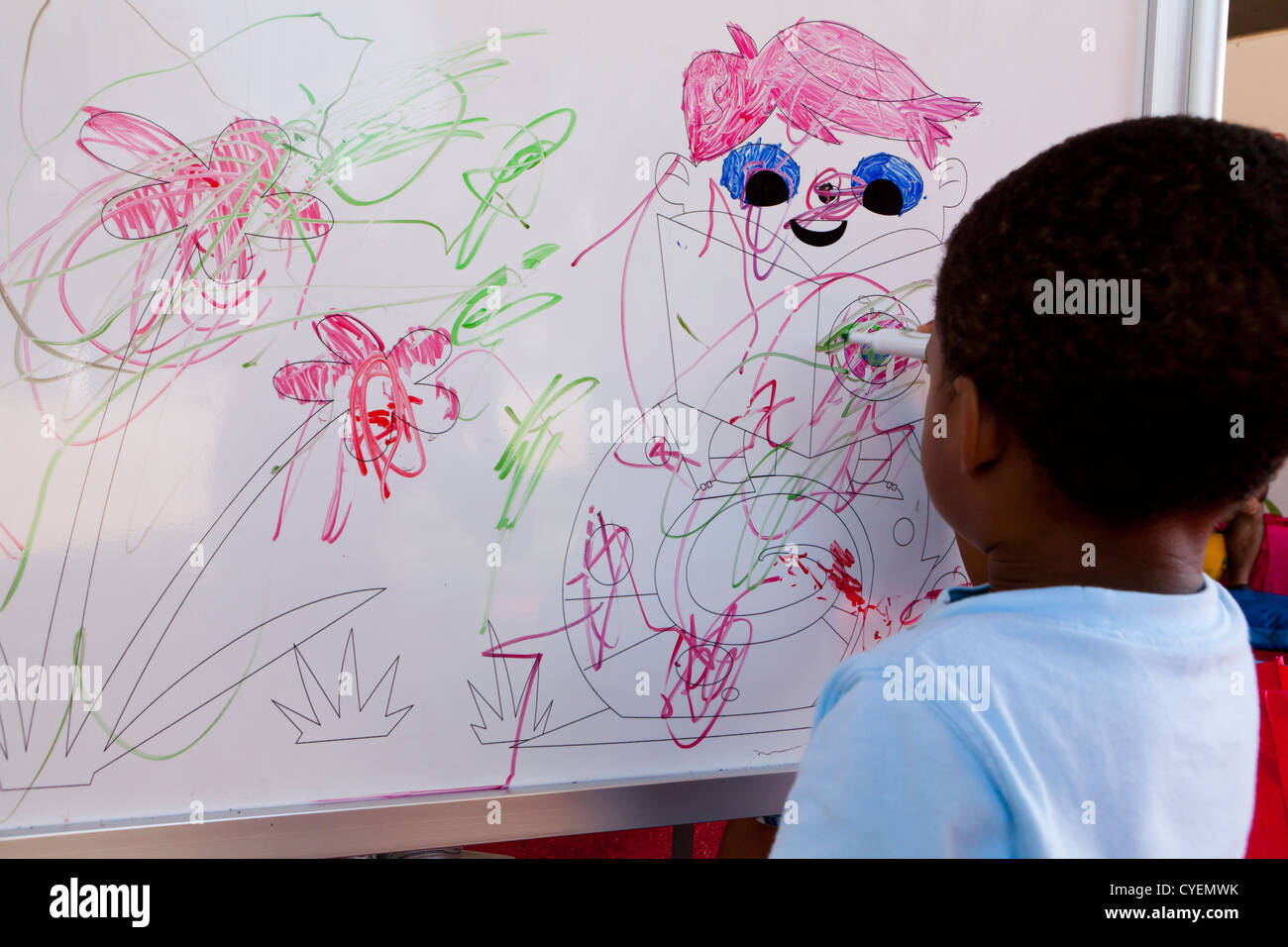 African-American child drawing on whiteboard Stock Photo