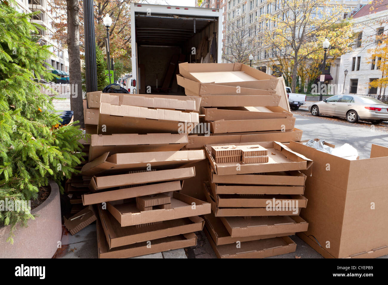 Empty cardboard boxes stacked behind moving truck Stock Photo
