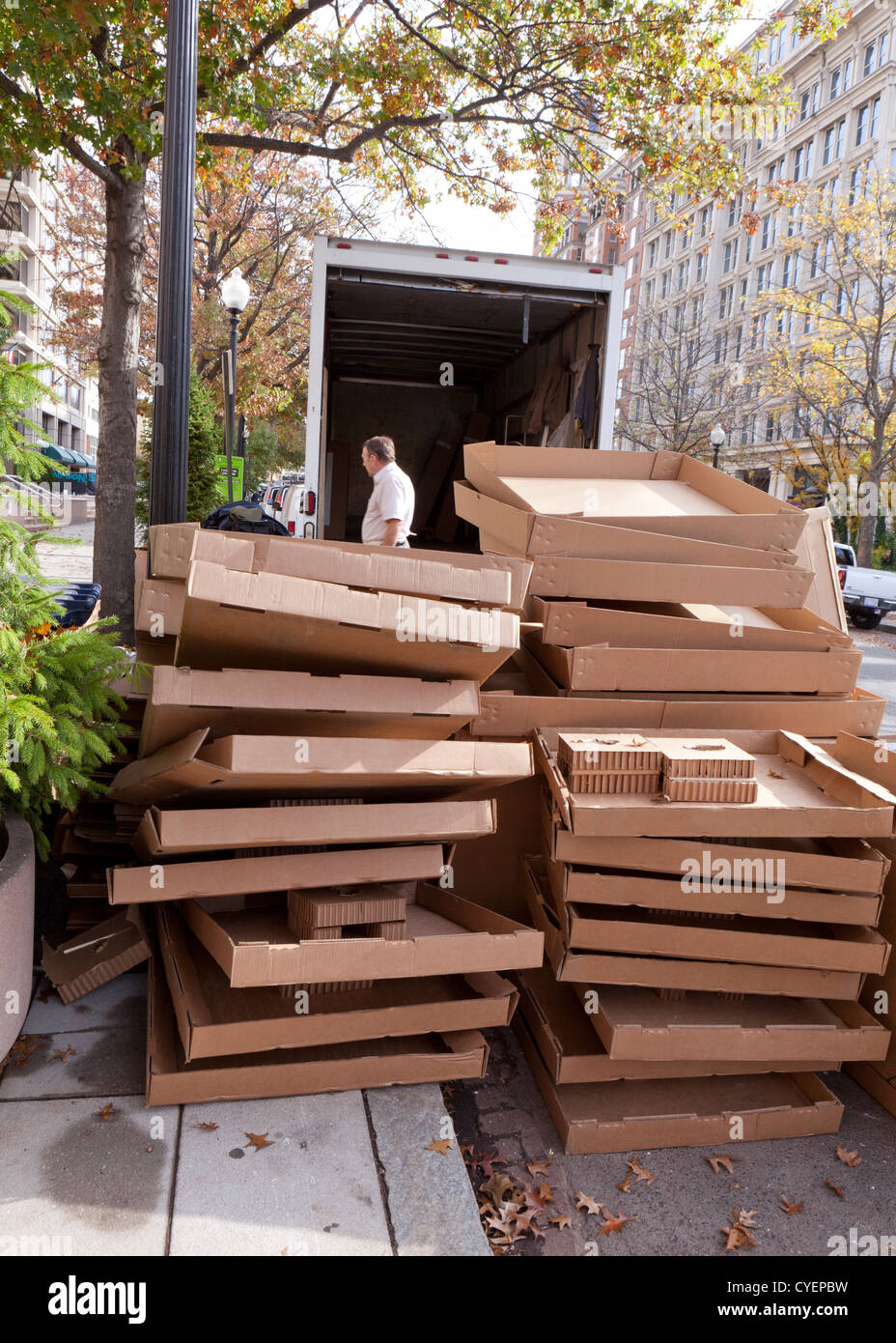 Empty cardboard boxes stacked behind moving truck Stock Photo